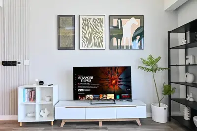 a living room with a tv on a white wall at Comfy 2BR Act 1 Near Dubai Mall in Dubai
