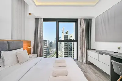 a bedroom with a large white bed and a large window at Comfy 2BR Act 1 Near Dubai Mall in Dubai