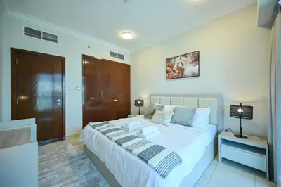 a bedroom with a large white bed in a room at Stylish 1BR in 8 Boulevard Walk in Dubai