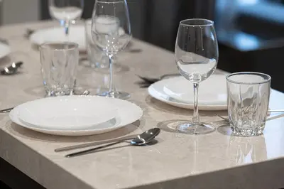 a table with glasses and plates and silverware on it at Lux 1 Bed room partment in Sobha Creek Vistas Reserve tower at 9th floor in Dubai