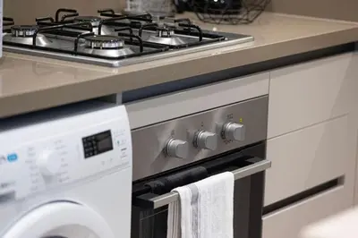 a stove top oven in a kitchen next to a washing machine at Lux 1 Bed room partment in Sobha Creek Vistas Reserve tower at 9th floor in Dubai