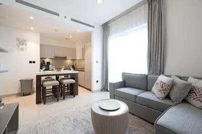 a living room with a couch and a kitchen at Lux 1 Bed room partment in Sobha Creek Vistas Reserve tower at 9th floor in Dubai