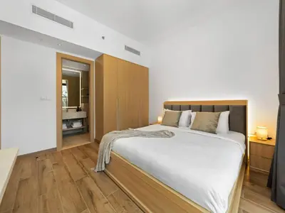 a bedroom with a large white bed and wooden floors at Brand New Luxury 2Bedroom in JVC with 5 Star Amenities in Dubai