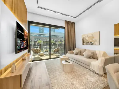 a living room with a couch and a tv at Brand New Luxury 2Bedroom in JVC with 5 Star Amenities in Dubai