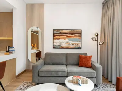 a living room with a couch and a table at Brand New Luxury 2 Bedroom with Padel Gym Pool Cinema in Dubai