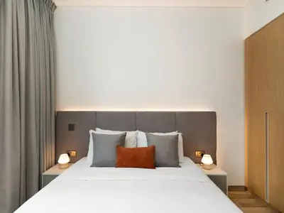 a bedroom with a large white bed with two lamps at Brand New Luxury 2 Bedroom with Padel Gym Pool Cinema in Dubai