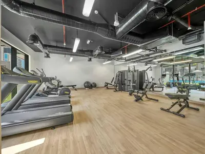 a gym with treadmills and machines in a room at Brand New Luxury 2 Bedroom with Padel Gym Pool Cinema in Dubai
