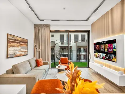 a living room with a couch and a tv at Brand New Luxury 2 Bedroom with Padel Gym Pool Cinema in Dubai
