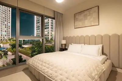 a bedroom with a large bed and a large window at Seraya Residence 1 - 4BDR - Burj Views - Amenities in Dubai