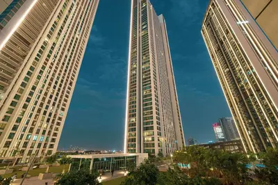 three tall buildings in a city with a blue sky at Seraya Residence 1 - 4BDR - Burj Views - Amenities in Dubai