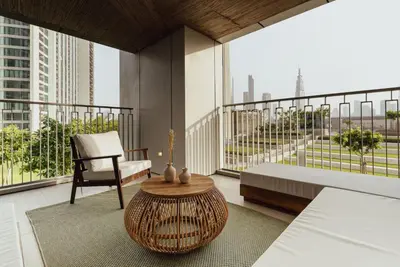 a balcony with a chair and a table on a building at Seraya Residence 1 - 4BDR - Burj Views - Amenities in Dubai