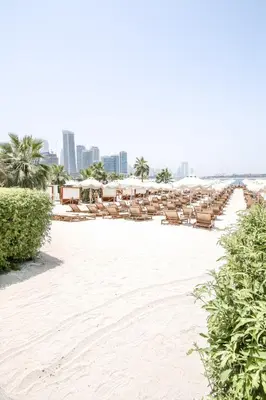 a beach with chairs and umbrellas on the sand at Sea-View Studio at Seven Palm in Dubai