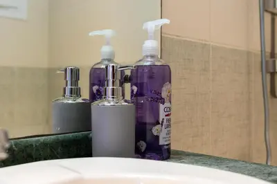 two bottles ofodorizers are sitting on a bathroom sink at White Sage High Floor 1BR Metro Access JLT in Dubai