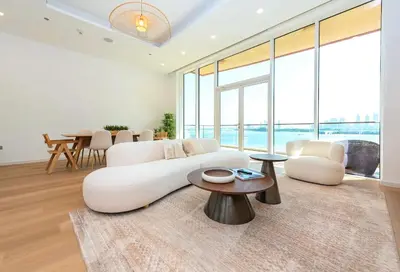 a living room with a white couch and a table at Tiara Residence, The Palm - Elegant 1BR with Full Sea View in Dubai