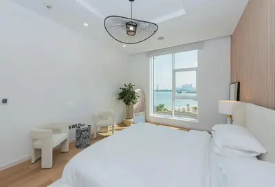 a white bedroom with a large bed and a window at Tiara Residence, The Palm - Elegant 1BR with Full Sea View in Dubai