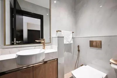 a white bathroom with a sink and a mirror at Cozy & Spacious 2 BHK Downtown in Dubai