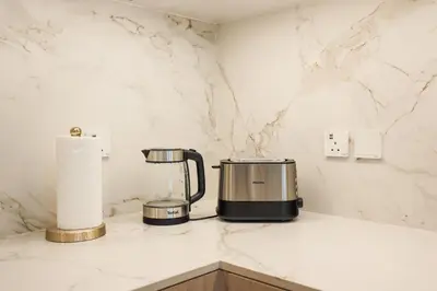 a kitchen counter with a coffee maker and paper towels at Stylish Studio at Berkeley Place by Ellington in Dubai