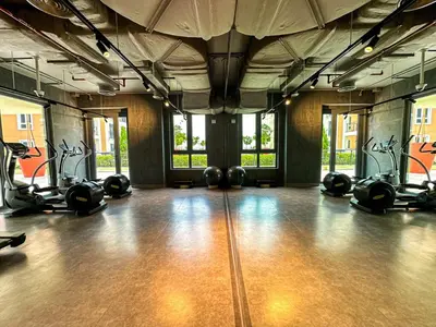 a gym with several treadmills and exercise bikes at HiGuests - Breezy 1 BR Retreat Near La Mer Beach in Dubai