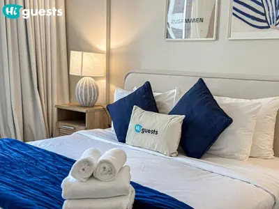 a bedroom with a bed with towels on it at HiGuests - Breezy 1 BR Retreat Near La Mer Beach in Dubai