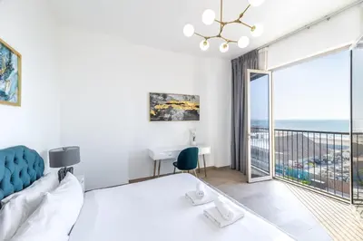 a bedroom with a bed and a view of the ocean at Goldbest Beachfront 2BR La Mer in Dubai