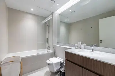 a bathroom with a sink and a toilet and a tub at Goldbest Beachfront 2BR La Mer in Dubai