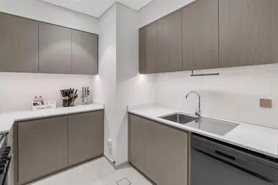 a kitchen with wooden cabinets and a sink at Full Burj Khalifa and Fountain View from All Rooms in Dubai