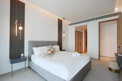 a bedroom with a large white bed and a desk at Livbnb Beachfront 2BR in Address JBR Sea & Ain Dubai Views in Dubai