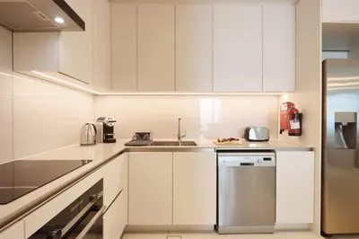a kitchen with white cabinets and a stainless steel dishwasher at Livbnb Beachfront 2BR in Address JBR Sea & Ain Dubai Views in Dubai