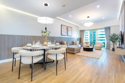 a dining room and living room with a table and chairs at High-Floor 2BR with Pool and City Views, Near Tram Station and Dubai Marina Walk, Marina Heights, Dubai Marina by Deluxe Holiday Homes in Dubai