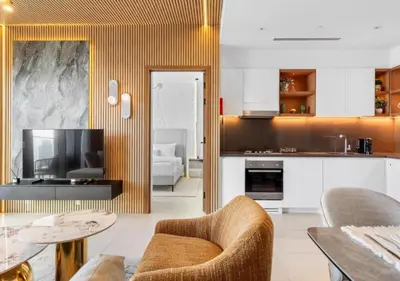 a living room with a television and a table and chairs at Novity Signature Homes in Dubai