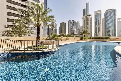 a swimming pool with a palm tree in a city at DREAM by Design Studio in Dubai