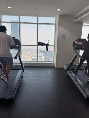 a group of people exercising on treadmills in a gym at Stylish 2BHK in Prime Location in Dubai