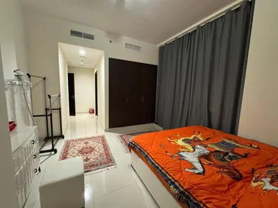 a bedroom with a bed with an orange blanket at Stylish 2BHK in Prime Location in Dubai