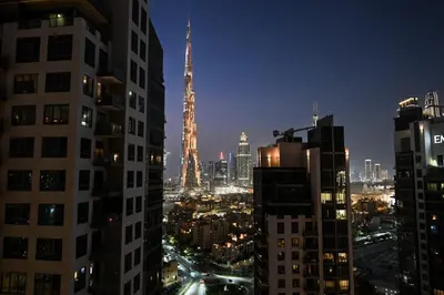 a view of a city at night with a tall building at Luxury 3BR Full Burj Khalifa View Stay by World's Tallest Tower in Dubai
