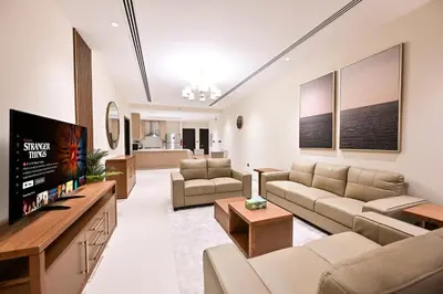 a living room with couches and a flat screen tv at Luxury 3BR Full Burj Khalifa View Stay by World's Tallest Tower in Dubai