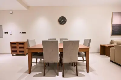 a dining room with a wooden table and chairs at Luxury 3BR Full Burj Khalifa View Stay by World's Tallest Tower in Dubai