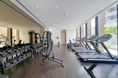a gym with a row of treadmills and machines at Seraya at Residence 110 in Dubai