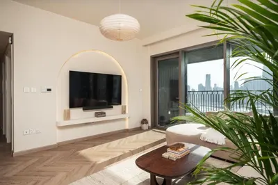 a living room with a tv and a couch and a table at Seraya Residence 7 - 4BDR - Burj and DIFC skyline Views in Dubai