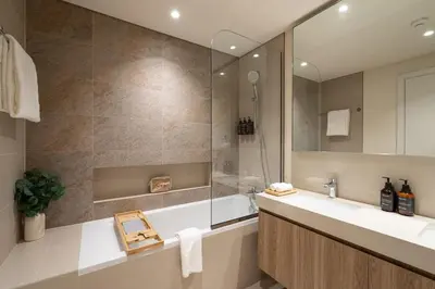 a bathroom with a tub and a sink and a mirror at Seraya Residence 9 - 4BDR - Skyline and Burj View - 3 Balconies in Dubai