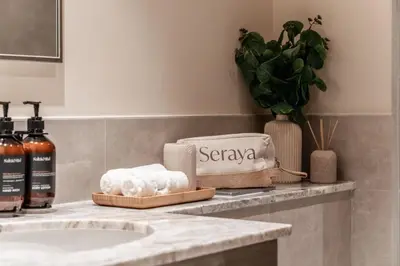 a bathroom counter with a sink with towels on it at Seraya Residences at Forte in Dubai