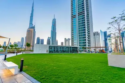 a park in the middle of a city with tall buildings at Seraya Residences at Downtown Views 2 in Dubai