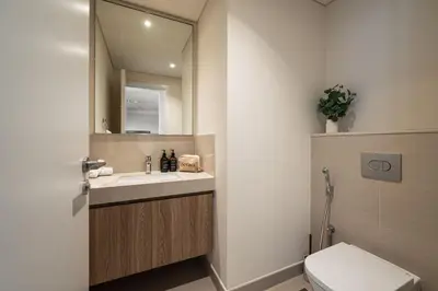 a bathroom with a sink and a mirror and a toilet at Seraya Residences at Downtown Views 2 in Dubai