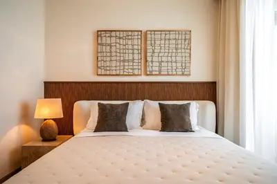 a bedroom with a large bed with a wooden headboard at Seraya Residences at Downtown Views 2 in Dubai