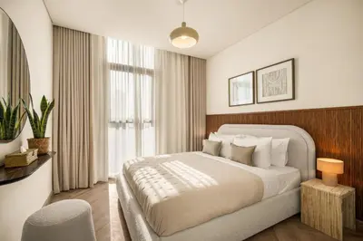 a bedroom with a large bed and a chair at Seraya Residences at Burj Crown in Dubai