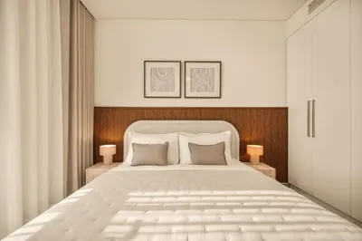 a bedroom with a large white bed with two lamps at Seraya Residences at Burj Crown in Dubai