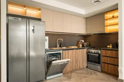 a kitchen with a stainless steel refrigerator and a dishwasher at Seraya Residences at Burj Crown in Dubai