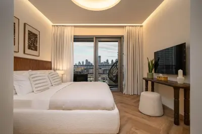 a bedroom with a white bed and a large window at Seraya Residence 14 - 4 BDR - Burj Views - Big Balcony in Dubai