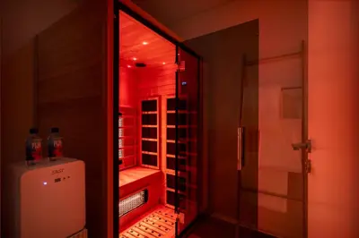 a small bathroom with a refrigerator and red lighting at Seraya Residence 12 - 3BDR - Hot Tub on patio with Burj view in Dubai