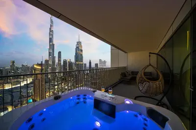 a hot tub in a room with a view of a city at Seraya Residence 12 - 3BDR - Hot Tub on patio with Burj view in Dubai
