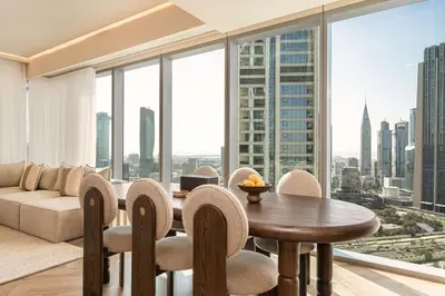 a living room with a table and chairs and a couch at Seraya Residence 15 - 3BDR - Burj View and Dubai Mall access in Dubai